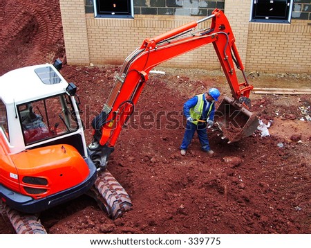 Small Orange digger having its bucket cleaned out