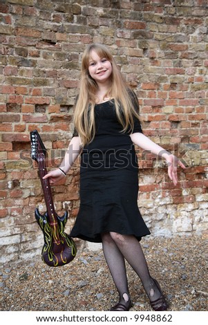 Cute blonde musician with an inflatable guitar