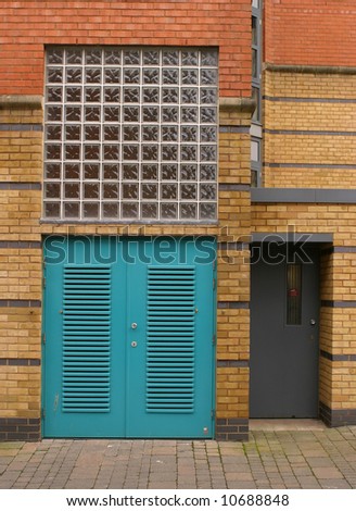 Architectural detail of blue doors with brickwork and glass bricks
