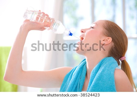 Young girl drinking water after exercise