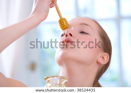 Young girl applying honey on her lips