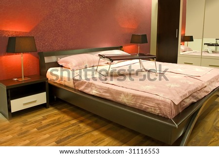 Interior of modern red bedroom with furniture and lamps