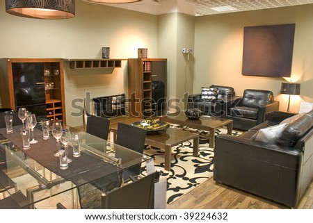 Luxurious living room with black leather sofa and arm chairs.