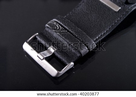 Closeup of leather watch strap on black background.