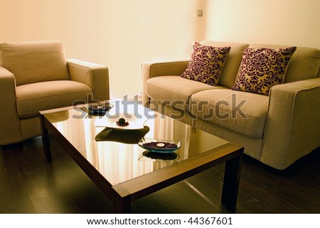 Living room with cosy sofa and arm chair and small table.