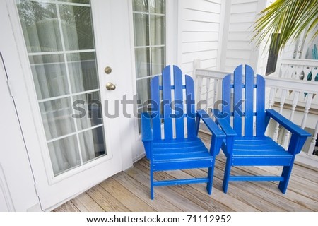 Relaxing Depiction Of Blue Adirondack Chairs In Key West Florida With A