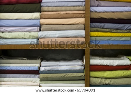 Shelves stacked with different shirt fabrics in Tailors