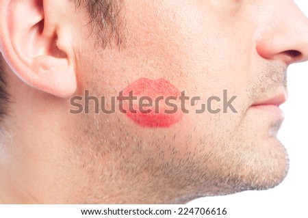 Closeup with red lipstick kiss shape on man's face