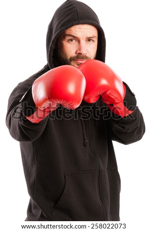 Amateur boxer wearing a black hoodie and red box gloves in the fighting position isolated on white background