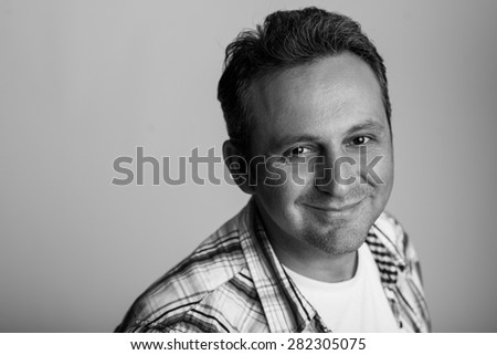 Black and white portrait of a friendly male model smiling to the camera