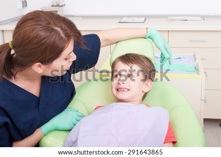 Smiling kid in dentist office with friendly woman doctor. No fear of dentist concept