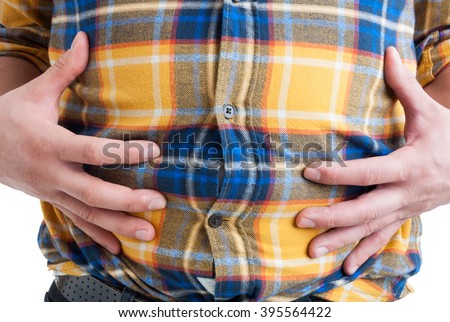 Close-up of man suffering from abdominal or stomach pain feeling distendend and full isolated on white background