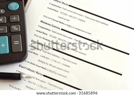 Calculator and pen on top of a business financial worksheet