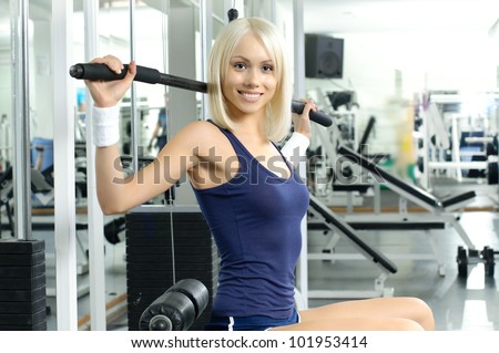 happy cutie athletic girl ,  execute exercise on sport-apparatus  and smile, in  sport-hall