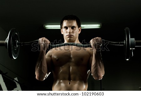 very power athletic guy ,  execute exercise with  weight, in  sport-hall, beauty glamour light
