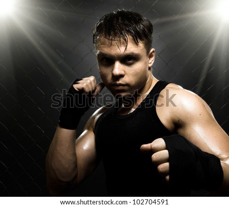 horizontal photo  muscular young  guy street-fighter,  aggression look, hard light