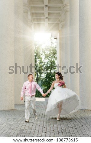 happy newly married couple  in white wedding dress running  and laughter