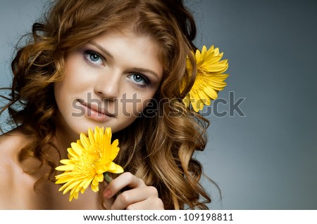 the very  pretty red-haired blue eyed young woman  with yellow flower,  smile , horizontal close up portrait