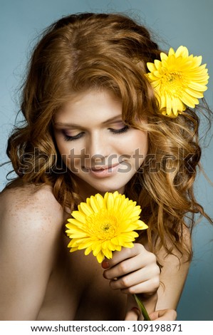 the very  pretty red-haired  young woman  with yellow flower,  smile , vertical close up portrait