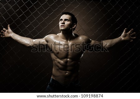 the very muscular handsome sexy guy ,  on  netting   steel fence