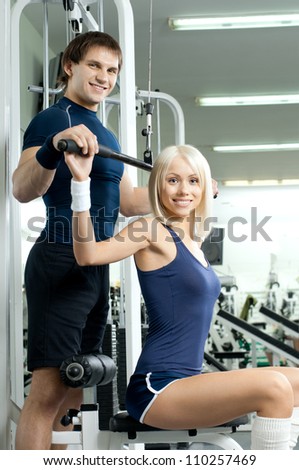 happy cutie athletic girl and guy,  execute exercise on sport-apparatus , in  sport-hall