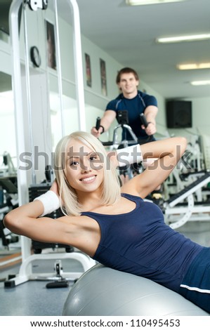 happy cutie athletic girl ,  execute exercise on muscles belly  and smile, in  sport-hall