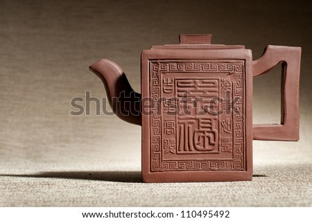 horizontal photo, still life of the one clay teapot  on brown background