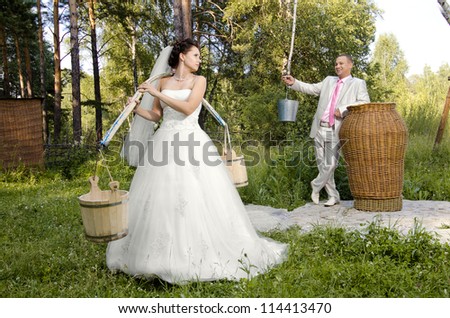 beautiful fiancee with yoke and  bucket, wedding humour photo
