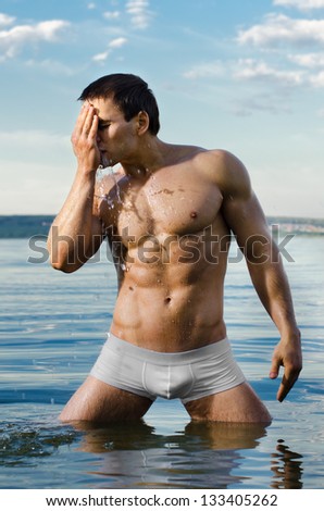 the very muscular handsome sexy guy in water and washing face