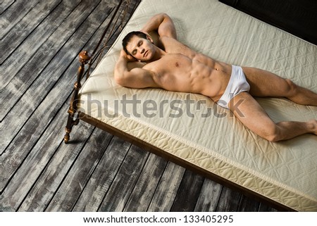 the very muscular handsome sexy guy, sleeping  lie on bed,  in  bedroom