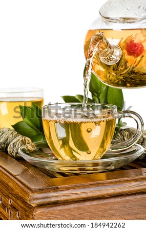 still life of the glass teapot flow green tea in cup on white background, isolated,  tea ceremony