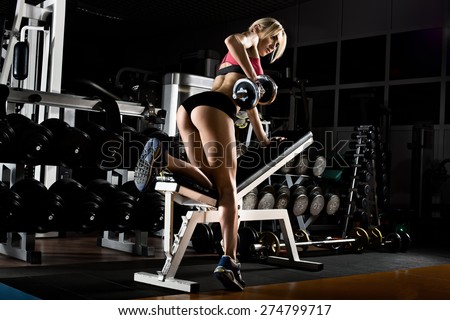 fitness girl  execute exercise with  dumbbells, on broadest muscle of back