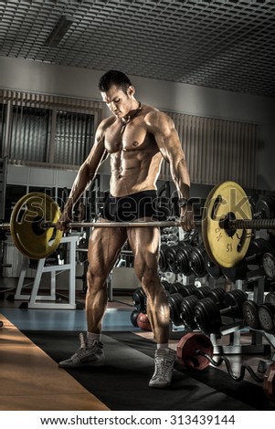 guy bodybuilder , execute exercise with weight in gym, vertical photo