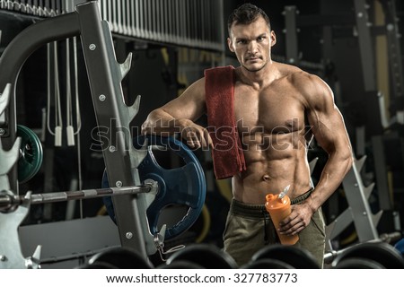 guy bodybuilder tired in gym hold shaker with sportive nutrition - protein of shaker , vertical photo