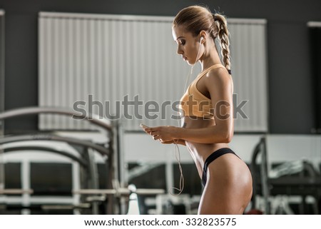 young fitness woman tired in gym and listen music with headset