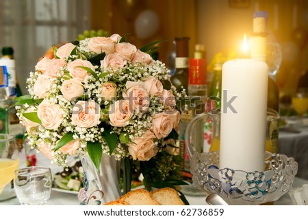 stock photo the Candles and wedding bouquet roses on a banquet table 
