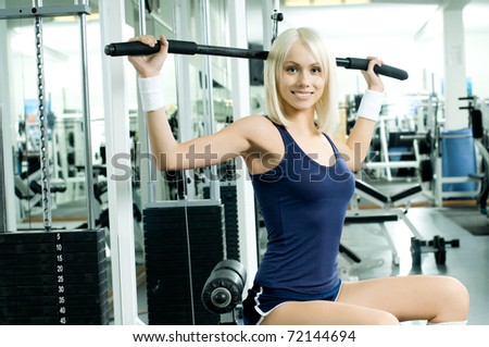 happy cutie athletic girl ,  execute exercise on sport-apparatus  and smile, in  sport-hall