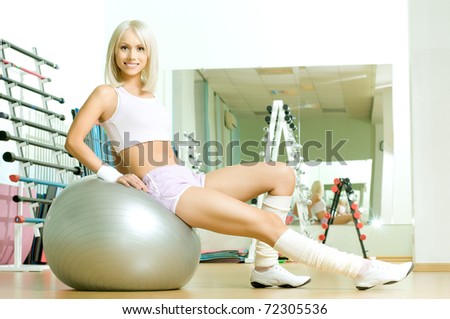 happy cutie athletic girl ,  sit  on fitnes balls and smile, in  sport-hall