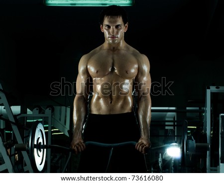 very power athletic guy ,  execute exercise with  weight, in  sport-hall, beauty glamour light