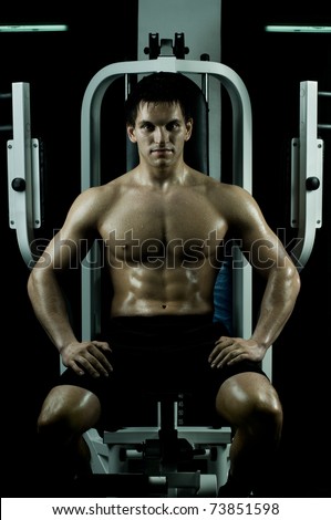 very power athletic guy ,  sit on  on sport-apparatus, in  sport-hall, beauty glamour light