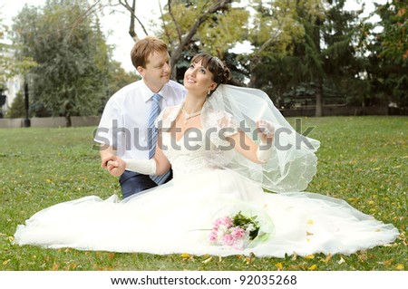 cutie happy married  couple  on nature in park ,  sit on lawn and smile