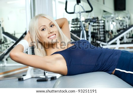 happy cutie athletic girl ,  execute exercise on muscles belly  and smile, in  sport-hall