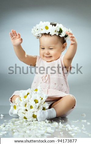beautiful  little kid with  bouquet and diadem of flowers , sit and  smile