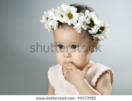 very beautiful  little kid with diadem of flowers,  sorrowful ,  closeup face