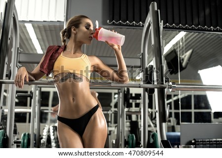 young fitness woman tired in gym drink sportive nutrition , Amino Acid or bcaa of shaker , horizontal photo