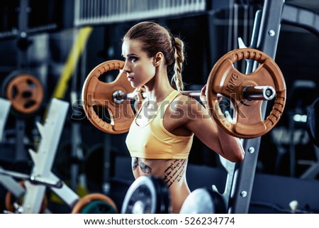 young fitness woman execute exercise with weight in gym, horizontal photo