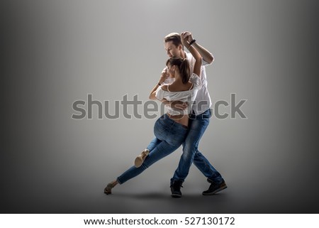 beauty couple dancing social danse ( kizomba or bachata or semba or taraxia) , on grey background