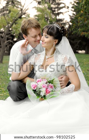 cutie happy married  couple  on nature in park ,  sit on lawn and smile