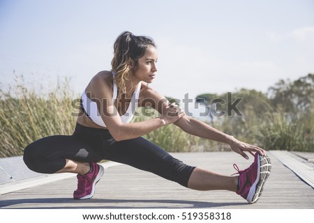 Attractive woman doing stretching exercises outdoors