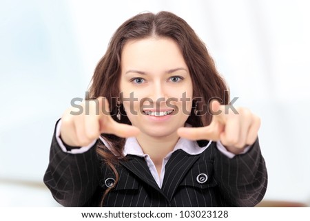 Beautiful businesswoman shows a forward index fingers in the office.